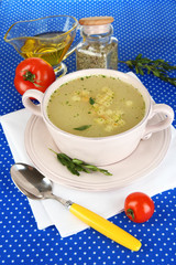 Nourishing soup in pink pan on blue tablecloth close-up