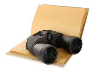 Black modern binoculars with old notebook isolated on white