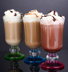 Layered coffee in glass on table on grey background