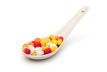 pills in a spoon on white with clipping path