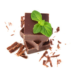 Closeup  of chocolate parts and mint leaves on white background