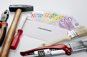Werkzeuge mit Geldscheinen im Umschlag