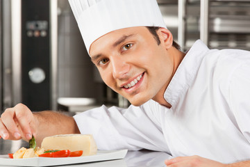 Happy Male Chef Garnishing Dish