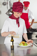 Female Chef Pouring Oil On Dish