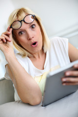 Fototapeta premium Funny girl in front of tablet with surprised look