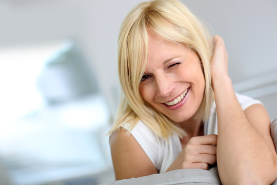 Sweet blond woman smiling with eyeblink