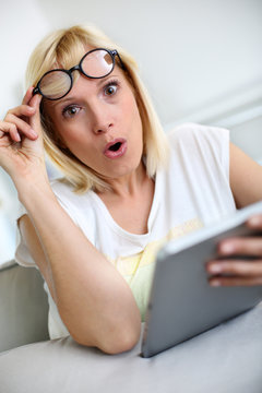 Funny girl in front of tablet with surprised look