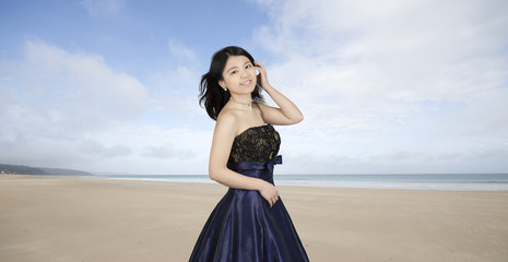 Fototapeta na wymiar asian woman in evening dress at the beach