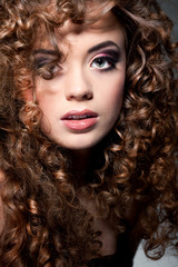 Fototapeta premium Young beautiful woman with long curly hairs