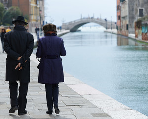 Old couple walking to the bridge in Venice