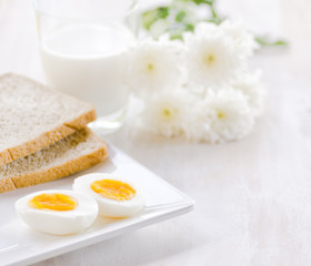 Boiled eggs, toasts and glass of milk