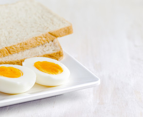 Boiled egg and toasts on white plate