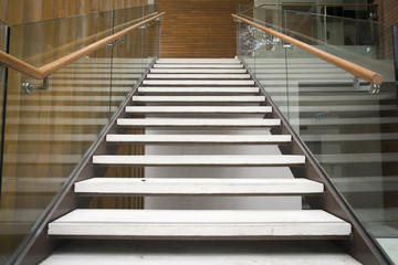 Modern white stairs with wooden handrail