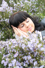 beautiful young brunette in a grass field of rosemary   