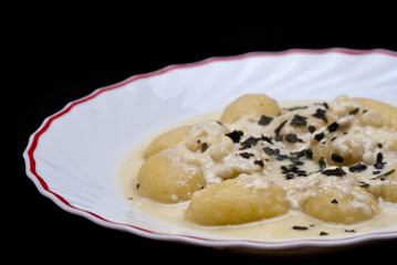 italian gnocchi with four cheese sauce isolated on black