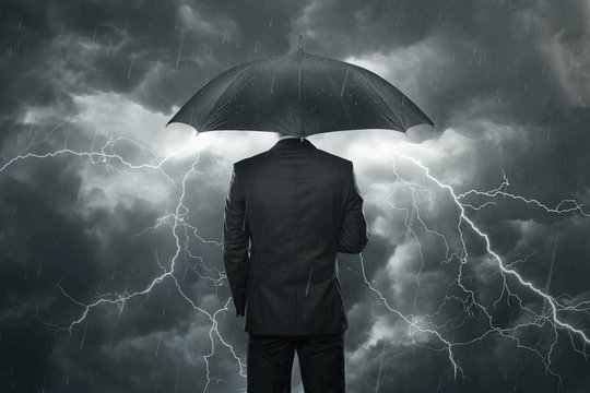 Businessman With Umbrella Standing In The Rain