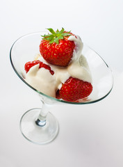 strawberries and cream in a glass on a white background