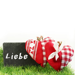 Fototapeta premium 2 Stoffherzen auf Gras mit Tafel 