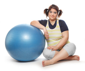 Overweight woman exercising with blue ball.