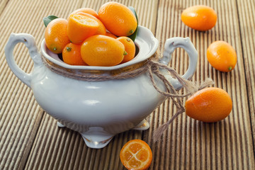 Ripe kumyauat with leaves in a bowl