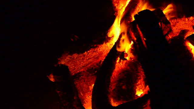 fire of a campfire with falling wood billets