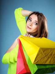 young woman with paper multi coloured shopping bag