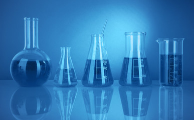 Test tubes with colorful liquids in blue light