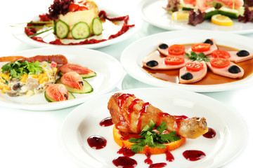 Small portions of food on big white plates close up