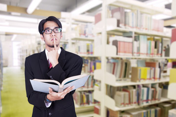 Businessman contemplating at library