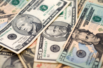 Money spread out with focus on the portraits on the 10, 20, and 