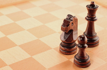 Three Wooden Chess Pieces on a Chessboard