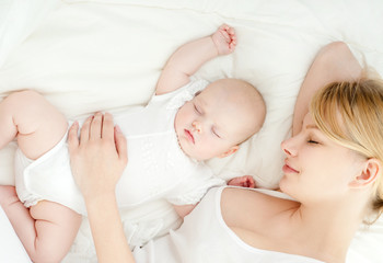 Young mother and her baby, sleeping in bed