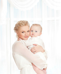 young mother with a baby in a beautiful bedroom