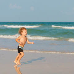 Little boy playing on the beach.