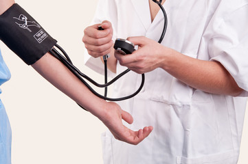 Doctor measuring blood pressure on white background
