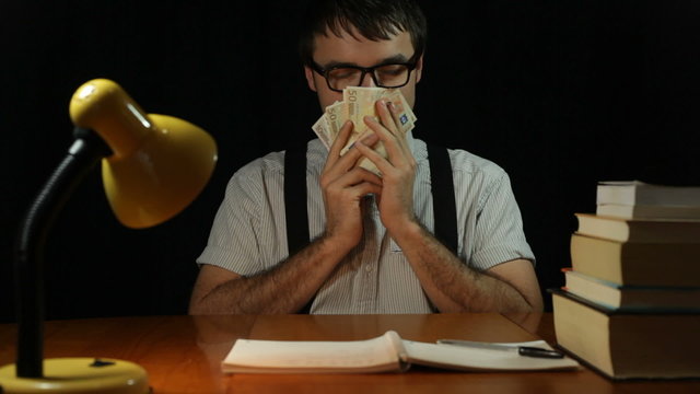 Happy nerd man caressing with his money