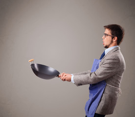 Young man holding a black frying pan