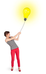 Happy woman holding a light bulb balloon