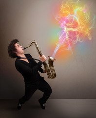 Attractive musician playing on saxophone with colorful abstract