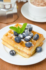Fototapeta na wymiar Belgian waffles with blueberries, coffee and fresh fruit