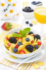 Cornflakes, fresh berries and orange juice for breakfast