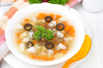 Fish soup with potatoes, carrots and olives horizontal top view