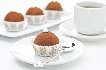 small chocolate cake on a plate and cup of coffee