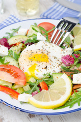 Vegetable salad with poached egg on a plate, vertical