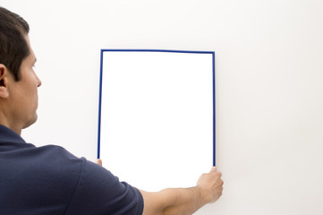 man putting a picture on the wall and space copy