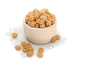 wholegrain pasta in a wooden bowl isolated horizontal