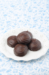 Marshmallows in chocolate on a white plate