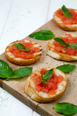 Fototapeta na wymiar bruschetta with tomato and basil on cutting board