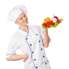 Woman chef looking at the plate of fresh vegetables. Isolated