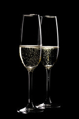 Two glasses of sparkling champagne infront of black
